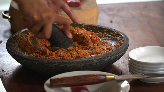 Use a mortar to grind together over 20 spices and create a paste