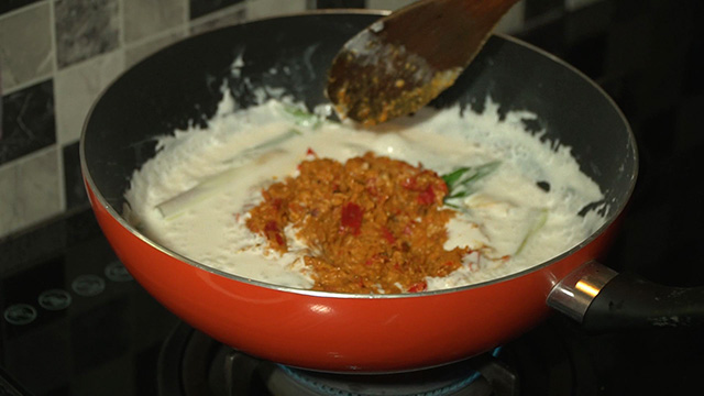 Add the spice paste to boiling coconut milk (this creates Rendang’s unique sweet and spicy flavor)