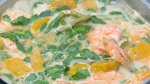 She simmers kabocha squash and green beans in the milk. They’re infused with the aroma of coconut! She then adds shrimp and moringa, a protein-rich herb. It's an essential ingredient in her family’s stew.