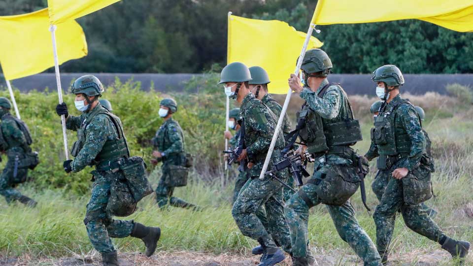 Тайваньские солдаты с пулеметами и гранатометами бегут во время учений по береговой обороне, имитирующих защиту от вторжения китайской армии, в Тайнане, Тайвань, 11 ноября 2021 года.