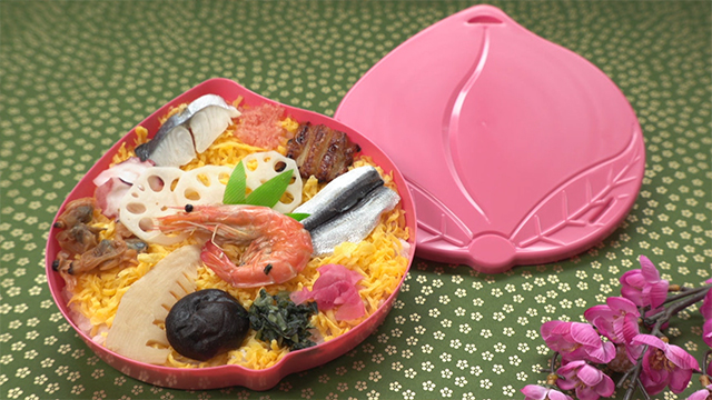 The cute container is in the shape of a peach, an homage to the Momotaro folk tale. It’s packed with bara-zushi. It consists of sushi rice topped with a colorful medley of fresh produce from both land and sea. It is often eaten on festive occasions.