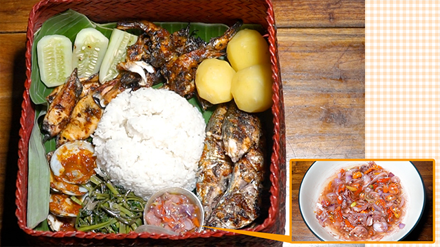 Ikan bakar is typically served with stir-fried Chinese water spinach and steamed potatoes. It's accompanied with sambal matah, a spicy condiment of chili peppers and shallots seasoned with seared fermented shrimp paste. Rahma packs everything into a huge bento box to go on a family picnic.